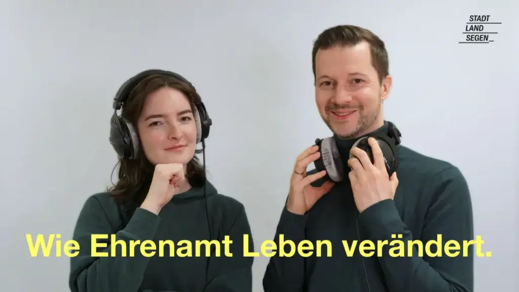 Das Bild zeigt zwei Menschen, die freundlich in die Kamera lächeln. Beide tragen einen Kopfhörer. Die Linke Person, Miriam, hat den Kopfhörer auf beiden Ohren aufgesetzt. Die rechte Person, Christian, trägt den Kopfhörer lässig um den Hals. Text: "Wie Ehrenamt Leben verändert".